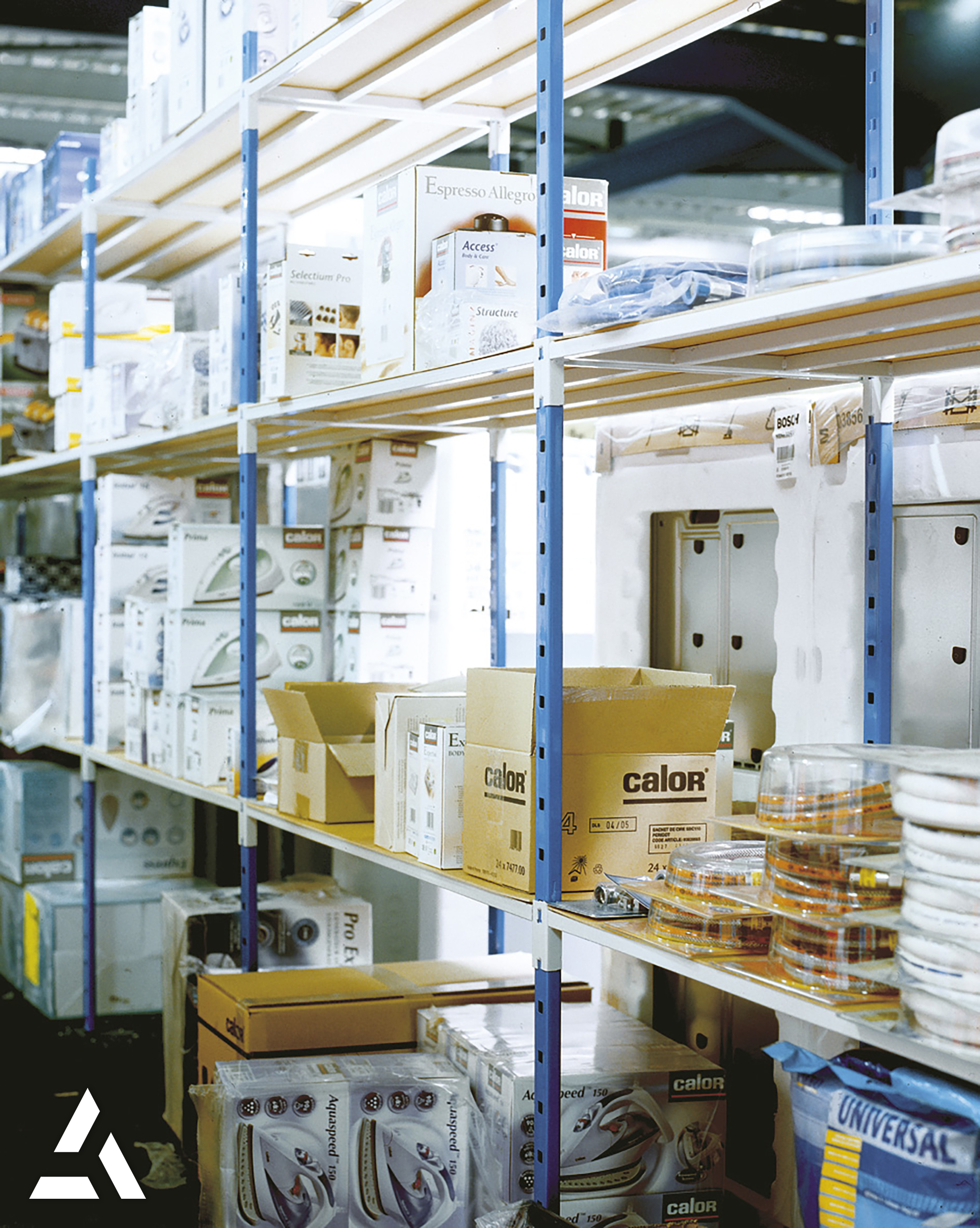 Rayonnages de stockage dans un entrepôt logistique contenant des produits électroménagers et articles conditionnés en cartons, organisation professionnelle des stocks pour la préparation et la gestion des commandes. 