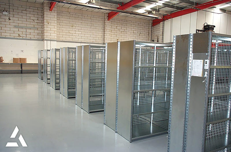 Rangées de rayonnages métalliques grillagés dans un entrepôt, stockage industriel sécurisé pour archives et marchandises