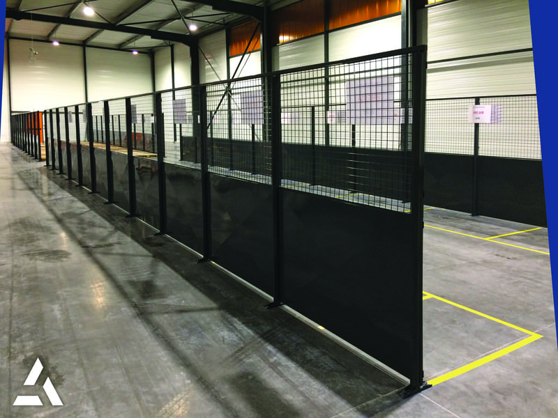 Cloisons grillagées métalliques en entrepôt industriel, délimitation sécurisée des zones de stockage et de travail