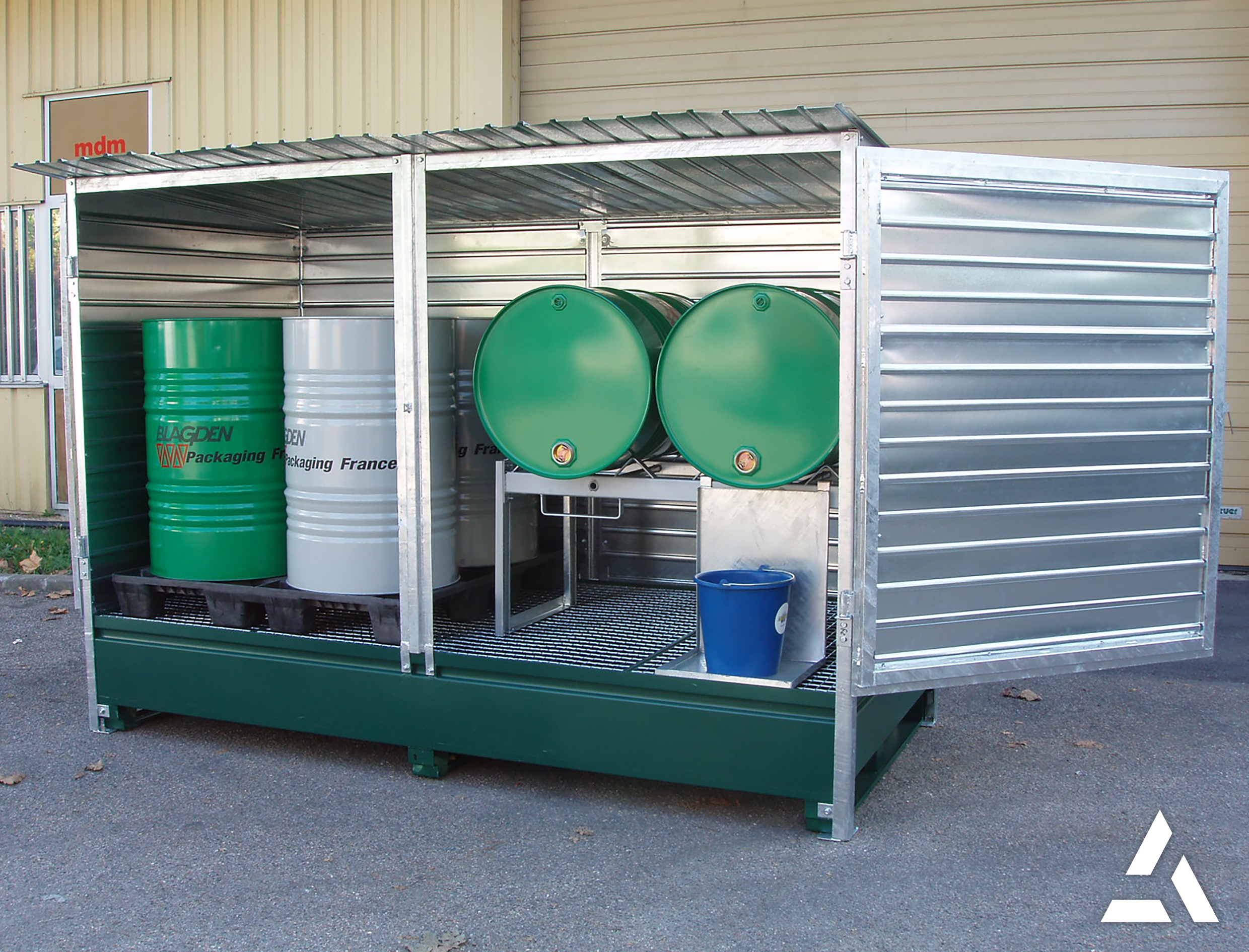 Local de stockage sécurisé avec bacs de rétention et fûts métalliques pour produits dangereux, conformité sécurité industrielle.