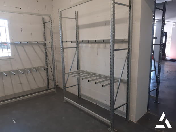 Rayonnage cantilever métallique galvanisé pour stockage de charges longues dans un entrepôt industriel.